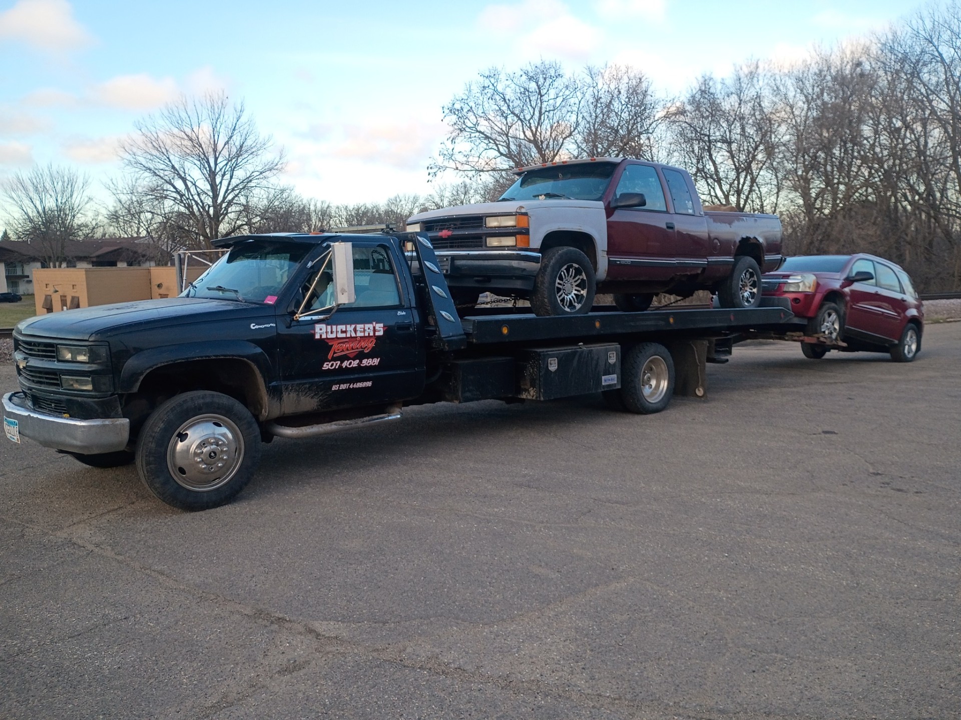 Ruckers Towing flatbed transporting two vehicles