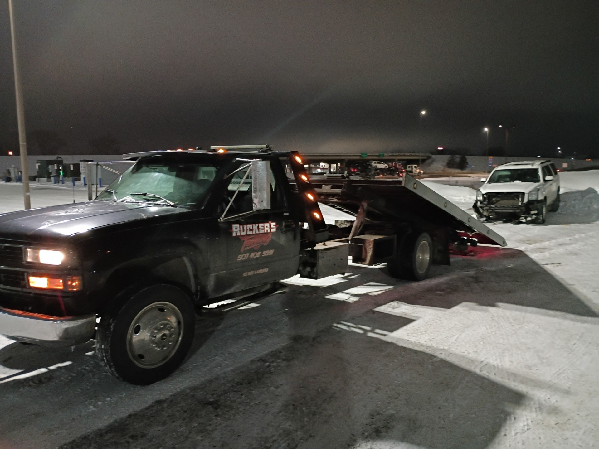 Ruckers Towing recovering a vehicle on a snowy night