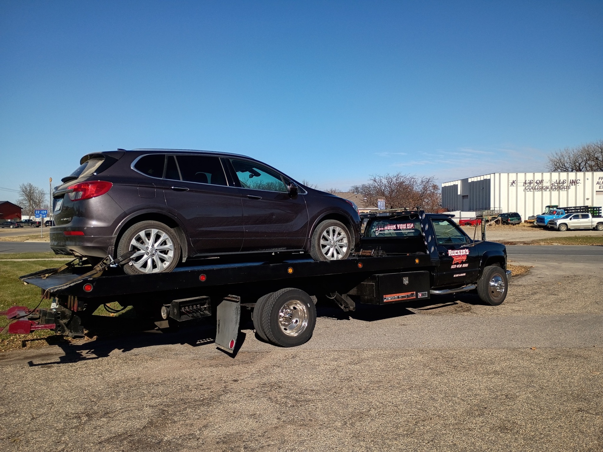 Ruckers Towing hauling a Buick SUV on a clear day